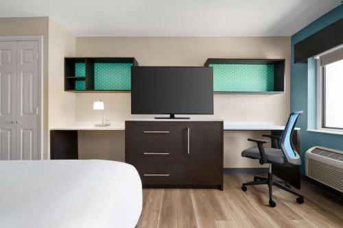 a bedroom with a bed and a desk with a television at La Quinta Inn by Wyndham Columbus Dublin in Dublin