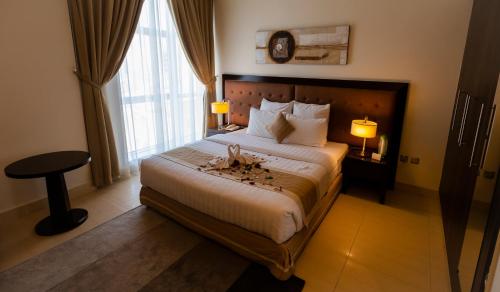 a hotel room with a large bed and a window at Imperial Suites Hotel in Doha