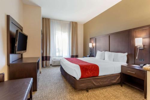 a hotel room with a bed and a flat screen tv at Comfort Suites Ontario Airport Convention Center in Ontario