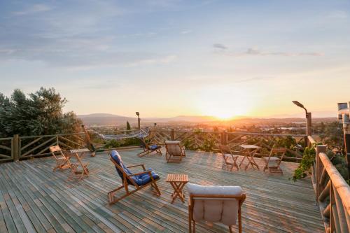 a deck with chairs and the sunset in the background at Urlachi Çiftliği in Urla