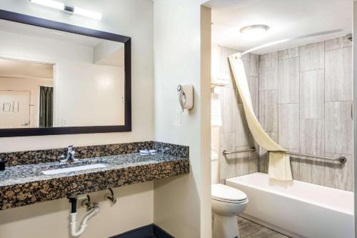ein Badezimmer mit einem Waschbecken, einem WC und einem Spiegel in der Unterkunft Rodeway Inn North Chesterfield-Richmond in Richmond