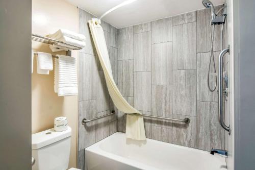 a bathroom with a white tub and a toilet at Brentwood Inn Richmond South in Richmond