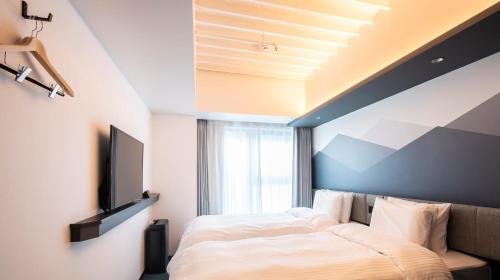 a bedroom with a bed and a television on a wall at Prince Smart Inn Kyoto Sanjo in Kyoto