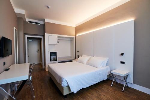 a bedroom with a bed and a desk and a television at Hotel Poledrini in Foligno