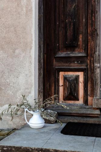 a white vase sitting in front of a door at Kalnciema kvartāla Kuldīgas rezidence in Kuldīga