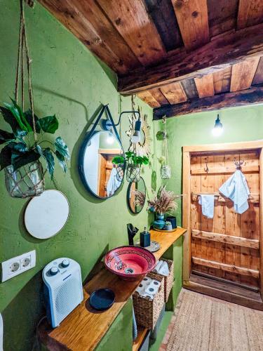a green room with a sink and a mirror at Nooks by AdyBeca - Balnaca Traditional Nook in Bălnaca