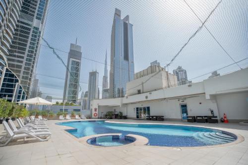 ein Schwimmbad in der Mitte eines Gebäudes mit hohen Gebäuden in der Unterkunft City Premiere Hotel Apartments - Dubai in Dubai