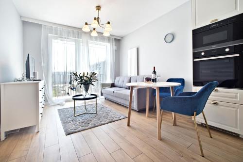P&O Serviced Apartments Posag 7 Panien - Ursus في وارسو: غرفة معيشة مع أريكة وطاولة