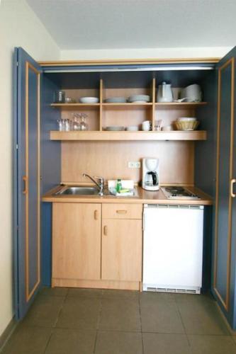 eine kleine Küche mit einer Spüle und einer Theke in der Unterkunft Yachthafenresidenz - Wohnung 6205 / 832 in Kühlungsborn