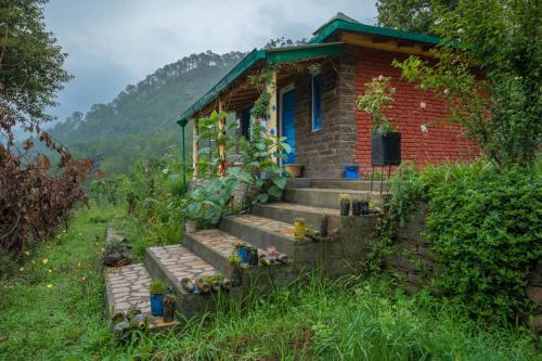 a small brick house with stairs in a field at Zenoaks Homestay in Almora