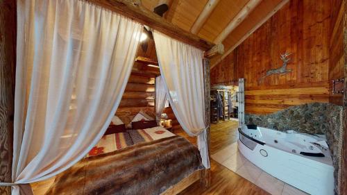 a bedroom with a tub in a log cabin at Willis Hütte in Zachenberg