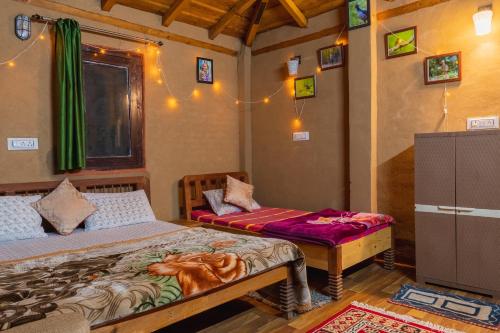 a bedroom with two beds and a dresser in it at Zenoaks Homestay in Almora