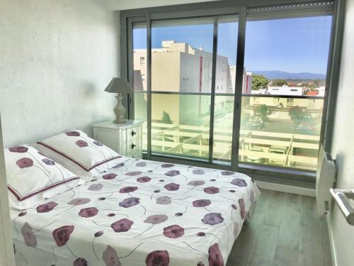 a bedroom with a bed and a large window at Appartement face à la mer - 6 à 8 personnes - Canet en Roussillon in Canet-en-Roussillon