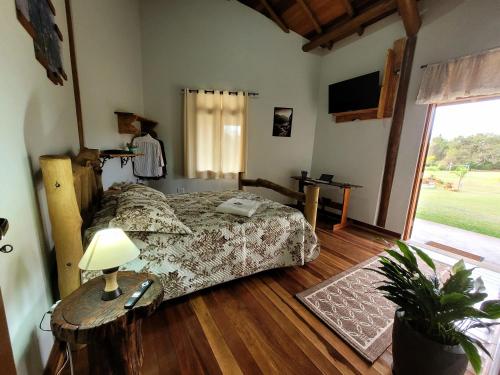 a bedroom with a bed and a table with a lamp at Recanto da Natureza in Brotas