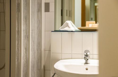 bagno con lavandino e specchio di ODELYA Hotel & Naturgarten Basel City a Basilea