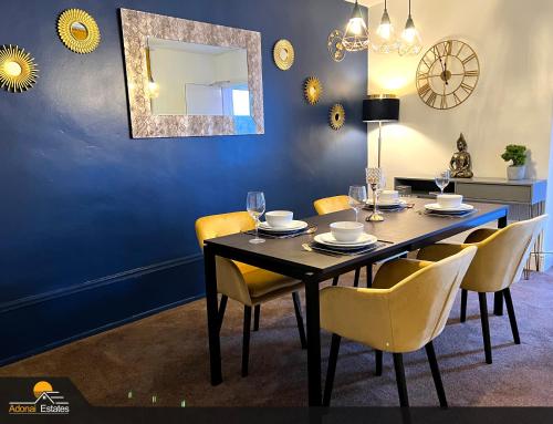 comedor con mesa con sillas y espejo en Priorswood House en Taunton