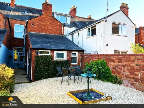 a backyard with a table and chairs and a building at Priorswood House in Taunton