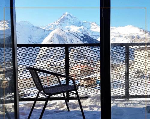 a chair on a balcony with a view of a mountain at Kazbegi Stylish Apartment in Kazbegi