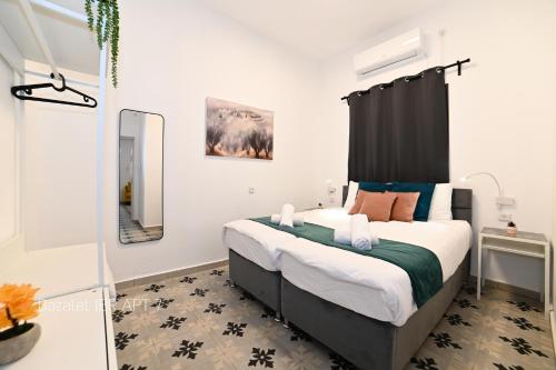 a bedroom with a large bed with a black headboard at Puy Bazelet Apartments in Tiberias