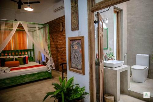 a bathroom with a bedroom with a bed and a sink at GODDESS Kandy in Kandy