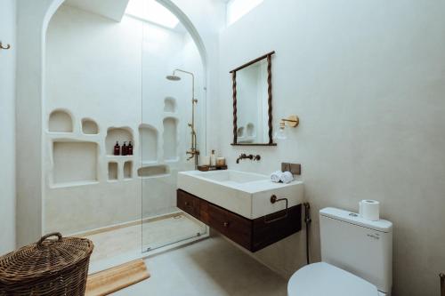 a bathroom with a sink and a shower and a toilet at Casa Viamo in Canggu