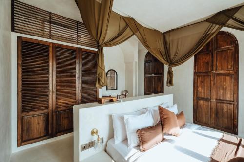 a bedroom with a white bed with brown and white pillows at Casa Viamo in Canggu