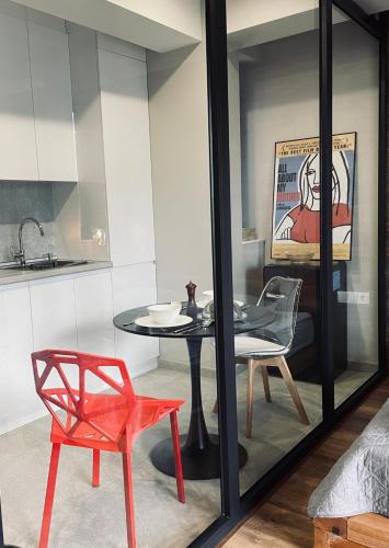 a dining room with a table and a red chair at Kazbegi Luxury Apartment in Stepantsminda