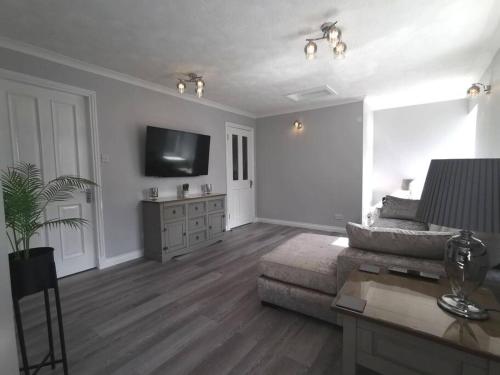 a living room with a couch and a flat screen tv at B'Dazzled Flat, Castletown in Thurso