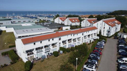 eine Luftansicht eines Parkplatzes mit weißen Gebäuden in der Unterkunft Yachthafenresidenz - Wohnung 6205 / 832 in Kühlungsborn