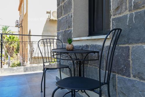 a small table and two chairs on a balcony at Bazelet Apartments in Tiberias