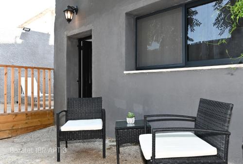 two chairs and a table on a patio at Bazelet Apartments in Tiberias