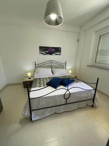 um quarto com uma cama grande e uma luz. em AcquaChiara em Marina di Ragusa