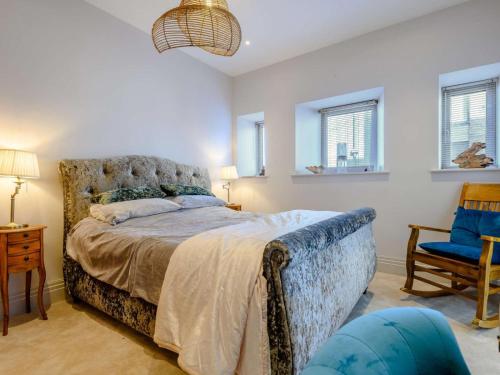 a bedroom with a bed and a blue chair at The Sandpiper's Pearl in Nottage