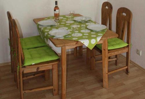 a dining room table with a green table and chairs at Ferienwohnung Herbert Best in Baiersbronn