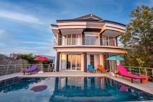 una casa con sillas y una piscina frente a ella en Sessiz,Sakin, huzurlu jakuzi ve saunalı deniz,doğa manzaralı müstakil villa, en Fethiye