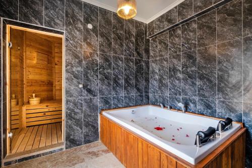 een badkamer met een bad en een douche bij Sessiz,Sakin, huzurlu jakuzi ve saunalı deniz,doğa manzaralı müstakil villa in Fethiye