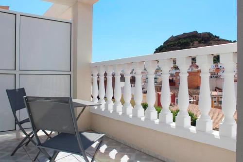 a chair on a balcony with a white fence at Hotel Sagunto in Sagunto