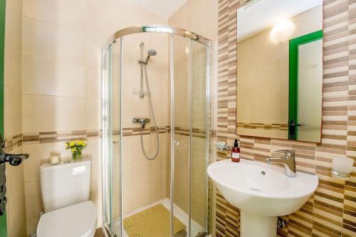 a bathroom with a shower and a toilet and a sink at The Valley Holiday Home in Kerċem