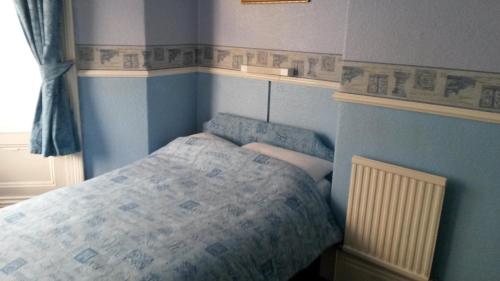 a bedroom with a bed in a blue room at Walford Hotel in Blackpool
