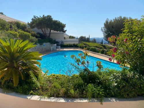 een groot blauw zwembad in een tuin bij Superbe T2 44m2 - Grande terrasse Vue mer panoramique exceptionnelle Piscine - Parking in Bandol
