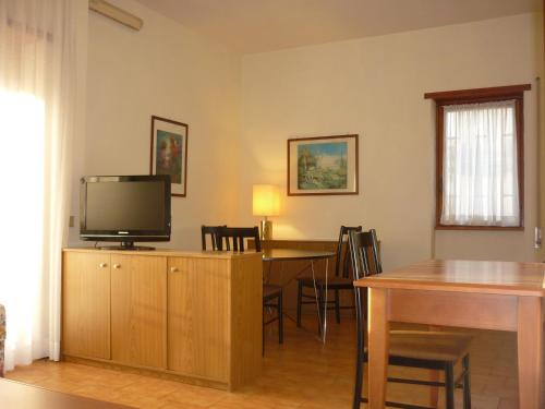 uma sala de estar com uma televisão e uma mesa de jantar em Eur Nir Residence em Roma