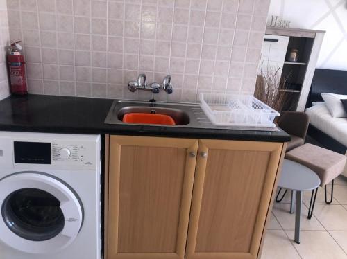 a kitchen with a sink and a washing machine at Panoramic Holidays - Superior 17 in Peyia