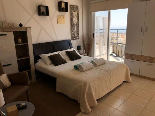 a bedroom with a large bed and a balcony at Panoramic Holidays - Superior 17 in Peyia