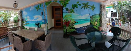 a dining room with a table and chairs and a mural at Dignadice's Homestay in Coron