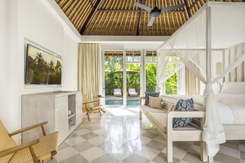 a bedroom with a bed and a living room at COMO Uma Ubud in Ubud