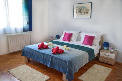 sypialnia z dużym łóżkiem z czerwonymi poduszkami w obiekcie Apartment Marigo w mieście Banjole