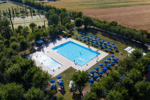 an overhead view of a swimming pool with blue umbrellas at Fattoria La Principina Hotel & Congress in Principina Terra