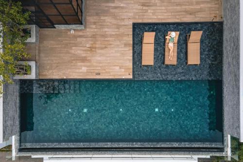 an overhead view of a swimming pool with two chairs at The Coach Hotel Sukhumvit - Asok BTS Bangkok in Bangkok