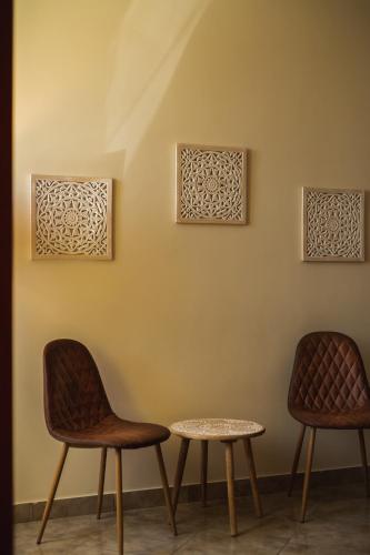 two chairs and a table against a wall at Apulia Hotel Taranto Ara Solis in Lido Azzurro