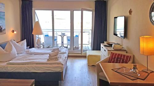 a hotel room with two beds and a large window at Yachthafenresidenz-Wohnung-9307-899 in Kühlungsborn